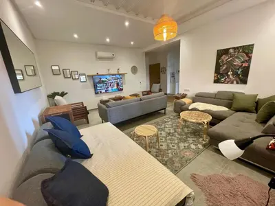 a living room with couches and a tv at Au Cœur Des Sables D’or - Harhoura in Temara