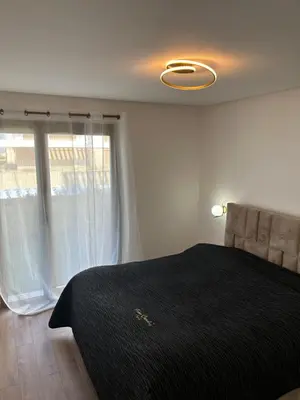 a bedroom with a bed and a large window at Le Carrousel Appartement in front of the see in Rabat