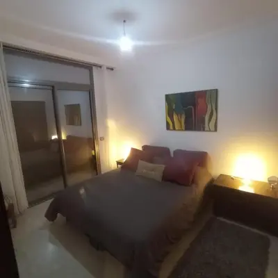 a bedroom with a bed and two lamps and a window at Bel appartement à skhirat plage et à 20 mn de Rabat in Skhirat