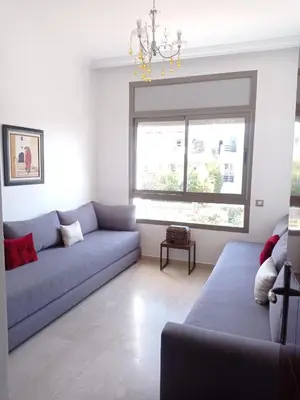 a living room with a blue couch and a window at Bel appartement à skhirat plage et à 20 mn de Rabat in Skhirat