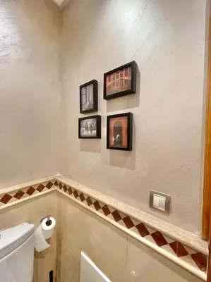 a bathroom with a toilet and three pictures on the wall at Appartement Cozy au Triangle d’or in Casablanca