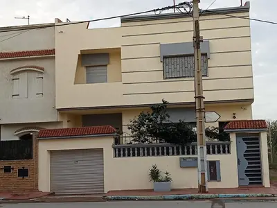 a house with two garage doors and a pole at Maison indépendante 100m2 à Témara centre in Temara