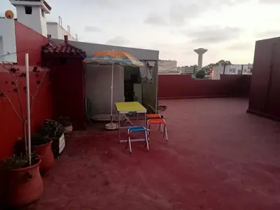 a patio with a table and two chairs and an umbrella at Maison indépendante 100m2 à Témara centre in Temara