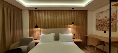 a bedroom with a large white bed and a desk at Unico Hotel & Spa Casablanca in Casablanca