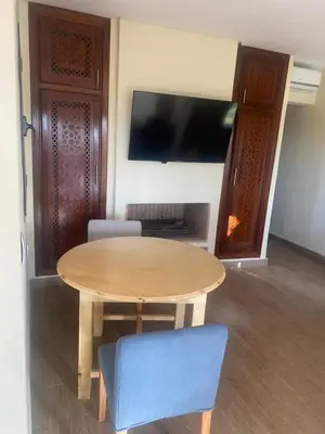 a wooden table and a blue chair in a room at Villa Tizra - Guest house in AÃ¯n el Ksob