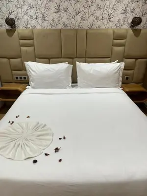 a white bed with some flowers on it at maarif elite suite in Casablanca