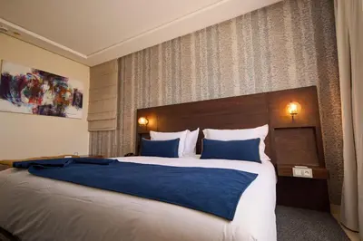a hotel room with a large bed with blue sheets at Fourteen Hotel Ain Sebaa in Casablanca