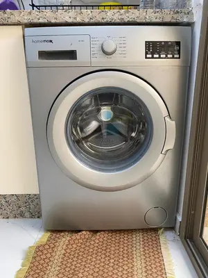 a washing machine is sitting in a kitchen at Chez Soad in Bouznika