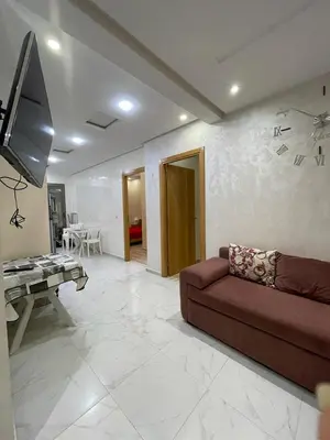 a living room with a couch and a television at Chez Soad in Bouznika