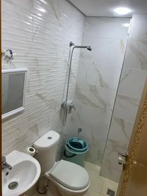 a bathroom with a toilet and a sink and a shower at Chez Soad in Bouznika