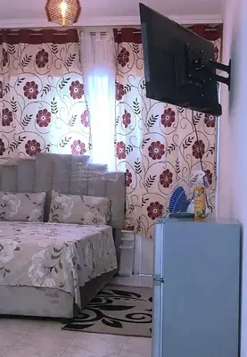 a bedroom with a bed and a flat screen tv at Mi mini estudio 1 in Rabat