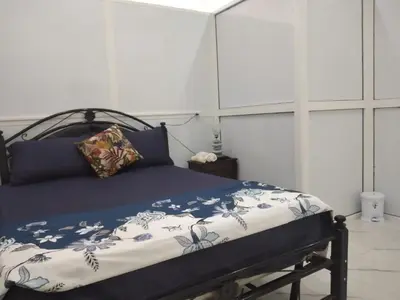 a bedroom with a bed with a blue and white comforter at Airport M V chambre stay in Deroua