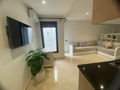 a living room with a couch and a tv at Quiet Top-Floor Studio by Med Faculty & Tram Lines in Casablanca