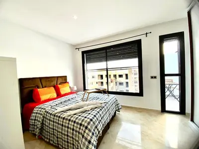 a bedroom with a bed and a large window at Quiet Top-Floor Studio by Med Faculty & Tram Lines in Casablanca