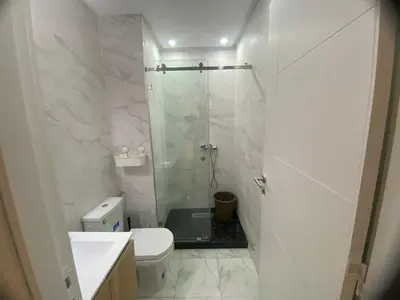 a white bathroom with a shower and a toilet at Quiet Top-Floor Studio by Med Faculty & Tram Lines in Casablanca
