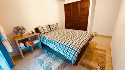 a small bedroom with a bed with a checkered blanket at Camilia Appart 2P TGV in Rabat