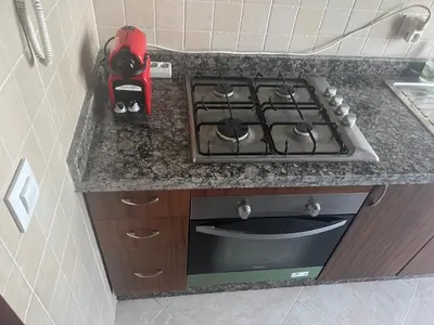 a stove top oven in a kitchen next to a counter at Camilia Appart 2P TGV in Rabat