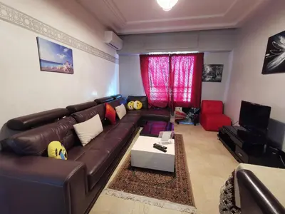 a living room with a brown leather couch and a tv at Blume Apartment Casa Port - 2 Bedrooms in Casablanca