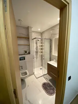 a bathroom with a shower and a toilet and a sink at Belle appartement à découvrir in El Harhoura