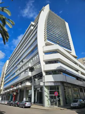 a tall building with cars parked in front of it at Cozy Apartment with Veranda Downtown in Casablanca