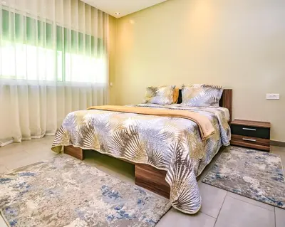 a bedroom with a bed and two rugs at Cozy Central - Gym & Spa Srvcs in Casablanca