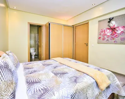 a bedroom with a bed and a bathroom at Cozy Central - Gym & Spa Srvcs in Casablanca