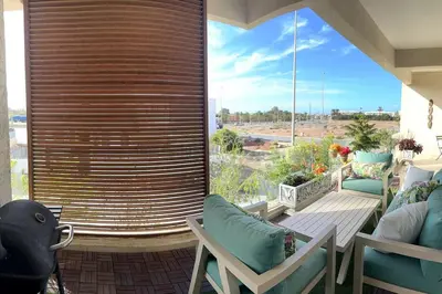 a room with a large window with chairs and a patio at Vague Bleue chez Makuja Home in Bouznika