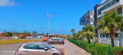 two cars driving down a street next to a building at Résidence de vacances vue piscine plages Mimosas Sablettes in Mohammedia