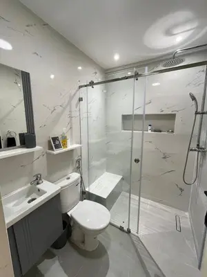 a bathroom with a shower and a toilet and a sink at Lovely 2 bedroom apartment in Rabat