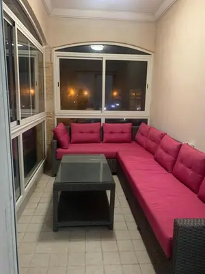 a large pink couch in a room with windows at Lovely apartment at Ola Blanca 2 with WiFi in Sidi Rahal