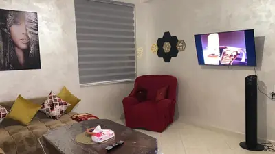 a living room with a couch and a red chair at Magnificent Sunlit Ground-Floor Apartment Netflix,Wi-Fi ,Comfort, Style in Casablanca