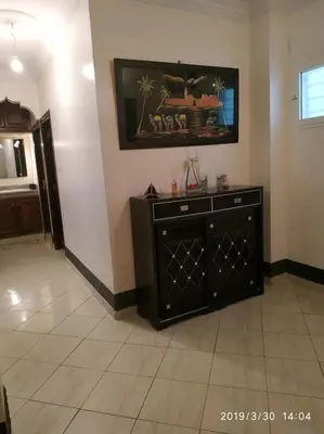 a living room with a black dresser in a room at Naj'Appart TEMARA WIFAK CALME SITUÉ PRÉS DE LA GARE FERROVIAIRE 4 MIN A PIED in Temara