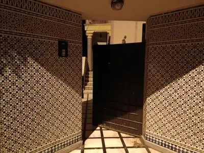 a bathroom with a black door and a tiled wall at Villa à la décoration marocaine in Rabat