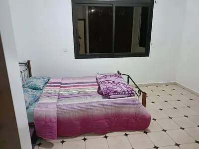 a bedroom with a bed with a purple comforter on it at Villa à la décoration marocaine in Rabat