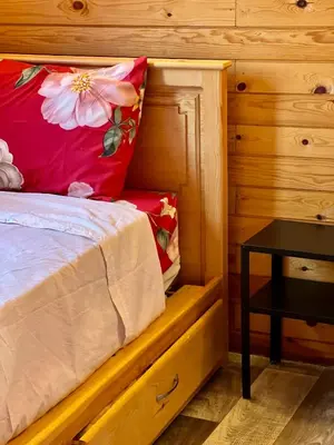a bed with a red pillow and a table in a room at Ecolodge Vert, Benslimane in Oulad Youssef