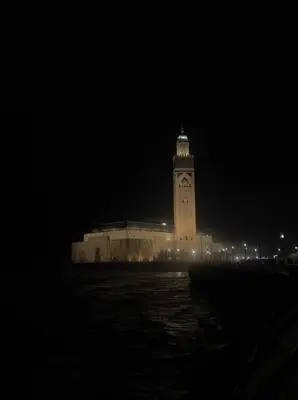 a large building with a clock tower at night at Central Holiday Apartment in Casablanca