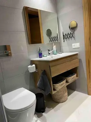 a bathroom with a toilet and a sink and a mirror at Central Holiday Apartment in Casablanca
