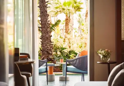 a room with palm trees and chairs and a window at Four Seasons Hotel Rabat at Kasr Al Bahr in Rabat
