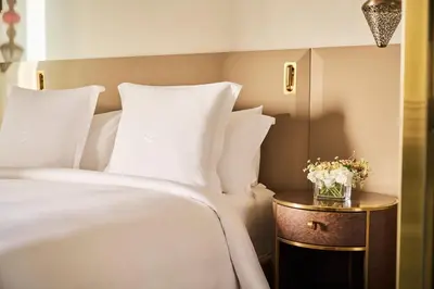 a bed with white pillows and a table with flowers at Four Seasons Hotel Rabat at Kasr Al Bahr in Rabat
