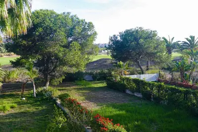 a garden with trees and flowers in a yard at Villa luxueuse au centre du golf in Bouznika