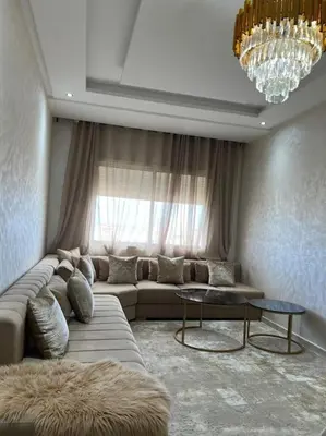a living room with a couch and a window at appartement meublé in Mohammedia