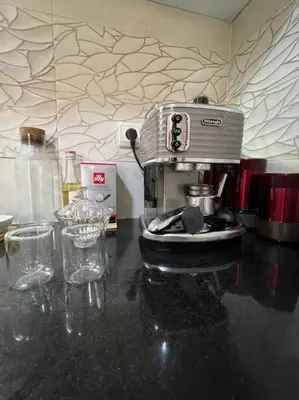 a coffee maker sitting on top of a counter with glasses at appartement meublé in Mohammedia