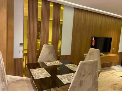 a dining room with a table and chairs and a television at Corniche Casablanca- Golden Hour in Casablanca