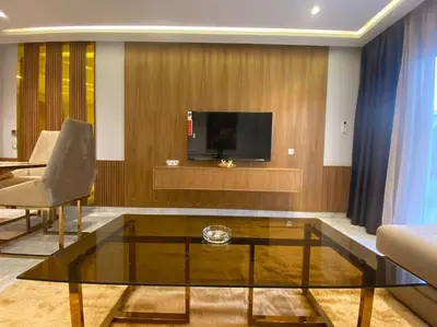 a living room with a glass coffee table and a tv at Corniche Casablanca- Golden Hour in Casablanca