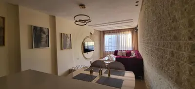 a living room with a table and a red couch at Le Bijou du Maarif in Casablanca