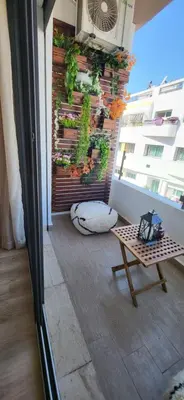 a balcony with a table and plants on a wall at Le Bijou du Maarif in Casablanca
