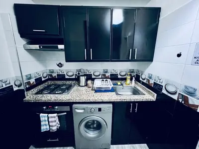 a small kitchen with a sink and a washing machine at Appartement très équipé etpropre 1 in Camp de Mediouna