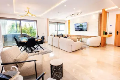 a living room with white furniture and a table at Appartement Duplex G1 in Casablanca