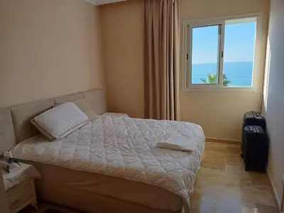 a bedroom with a bed and a window with the ocean at Appart 3p vue sur mer in Rabat