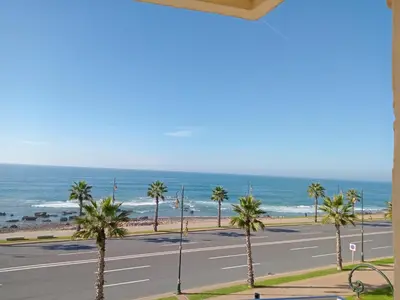 a view of a street with palm trees and the ocean at Appart 3p vue sur mer in Rabat